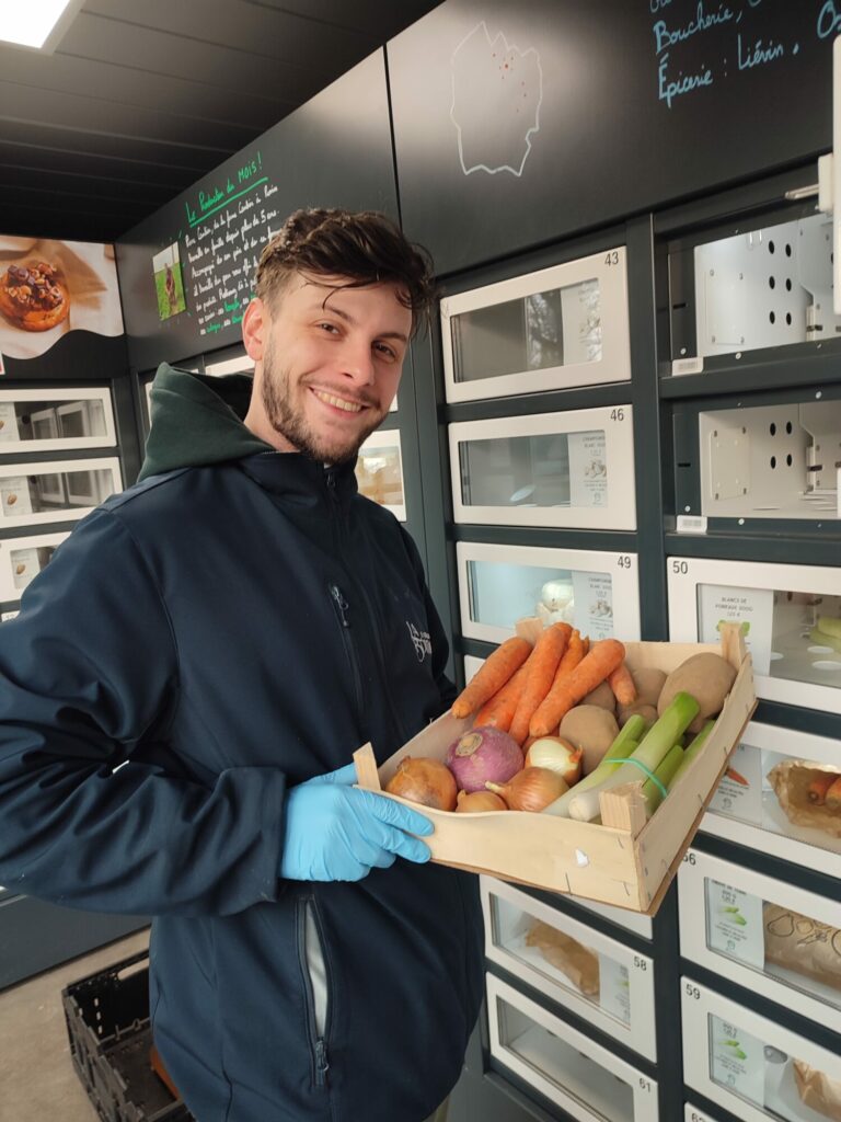 Un producteur de fruits et légumes remplit un casier réfrigéré Automat-e